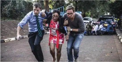  ?? - AFP ?? TERRIFIED: A woman is evacuated from the scene of an explosion at a hotel complex in Nairobi’s Westlands suburb on January 15, 2019, in Kenya.