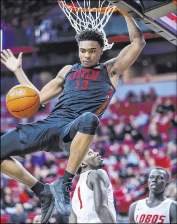  ?? L.E. Baskow Las Vegas Review-Journal @Left_Eye_Images ?? Rebels guard Bryce Hamilton finishes off a dunk in front of New Mexico Lobos Corey Manigault (1) and Makuach Maluach in UNLV’s 99-78 Mountain West win.