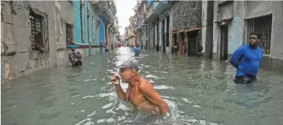  ??  ?? A Cuban man wades through a flooded street in Havana on September 10.