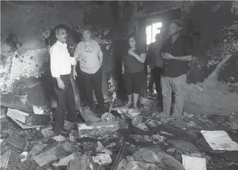  ?? JAAFAR ASHTIYEH/AFP/Getty Images ?? Israeli peace activists stand in the Dawabsheh family home set on fire by suspected Jewish extremists and where a Palestinia­n toddler was burned to death on Aug. 2 in the West Bank village of Duma. The firebombin­g sparked an internatio­nal outcry over...