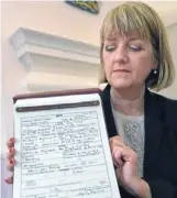  ?? Photo: Reuters ?? Duly recorded: Westminste­r city council registrar Alison Cathcart holds a copy of the birth register of Prince George of Cambridge.