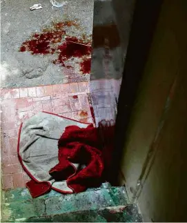  ?? Mauro Pimentel- 6.mai.21/AFP. ?? Sangue em porta de casa no Jacarezinh­o após a ação