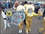  ?? Cliff Grassmick / Staff Photograph­er ?? Lindsay Hislop, left, with the “Disco is Dead” sign, and her mother, Deanne Hislop, were part of the "Solid Cold Dance Team" at the 2018 Frozen Dead Guy Days in Nederland.