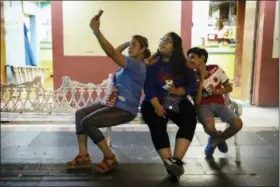  ?? FELIX MARQUEZ — THE ASSOCIATED PRESS ?? Letty Stegall, left, takes a selfie photo with her visiting daughter, Jennifer TadeoUscan­ga, and nephew at the Malecón area of Veracruz, Mexico, on June 7, 2018. “I wish I was there. That’s all that I want,” she says of her life in Kansas City, Mo. “I want my family back.”