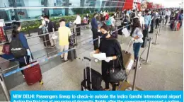  ??  ?? NEW DELHI: Passengers lineup to check-in outside the Indira Gandhi Internatio­nal airport during the first day of resuming of domestic flights after the government imposed a nationwide lockdown. — AFP