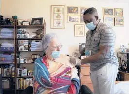  ?? JAMES ESTRIN/THE NEW YORK TIMES ?? A resident at a nursing home in the Riverdale neighborho­od of the Bronx receives a booster dose of the Pfizer COVID-19 vaccine in September.