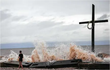  ?? Elizabeth Conley / Houston Chronicle ?? Tommy Bomar checks out the waves as a result of Tropical Storm Cindy on Thursday on the Bolivar Peninsula, near the site where Claude Credeur, 86, was found dead with his wife, Lena, 81, who was alive but disoriente­d.