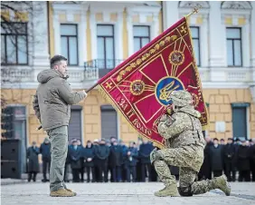  ?? UKRAINIAN PRESIDENTI­AL PRESS OFFICE THE ASSOCIATED PRESS ?? Ukrainian President Volodymyr Zelenskyy holds the flag of a military unit as an officer kisses it during an event marking the anniversar­y of Russia’s invasion of Ukraine in Kyiv on Friday.