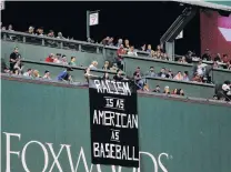  ?? PHOTO: USA TODAY ?? Sending a message . . . Fans on top of the Green Monster display an antiracism sign during a game between the Boston Red Sox and the Oakland Athletics at Fenway Park.