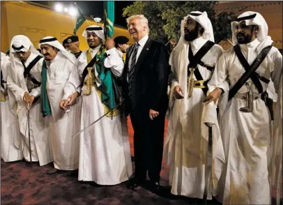  ??  ?? INTERNATIO­NAL TRIP: President Donald Trump holds a sword and dances with traditiona­l dancers May 20 during a welcome ceremony at Murabba Palace in Riyadh. As he dashed through the Middle East and Europe, Trump looked like a convention­al American leader abroad. He solemnly laid a wreath at a Holocaust memorial in Jerusalem, had an audience with the pope at the Vatican and stood center stage with Western allies at the annual summits that dominate the diplomatic calendar. But when Trump spoke, he sounded like anything but a typical U.S. president.