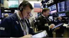  ?? RICHARD DREW — THE ASSOCIATED PRESS ?? William McInerney, left, works with fellow traders on the floor of the New York Stock Exchange, Friday.