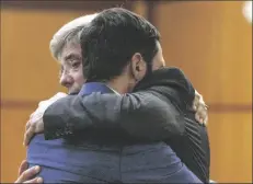  ?? PHOTOS BY ELLEN M. BANNER/ASSOCIATED PRESS ?? TACOMA POLICE OFFICER Christophe­r “Shane” Burbank (right) gets a hug from his attorney Wayne Fricke after he is declared not guilty for any charges related to the March 2020 killing of Manny Ellis in Pierce County Superior Court in Tacoma, Wash., on Thursday. Members of Manny Ellis’ family (in photo at left) react as the verdict is read.