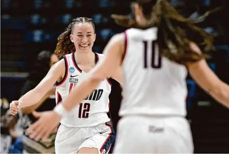  ?? ?? UConn’s Ashlynn Shade (12) celebrates with Nika Mühl during Saturday’s NCAA Tournament win over Jackson State.