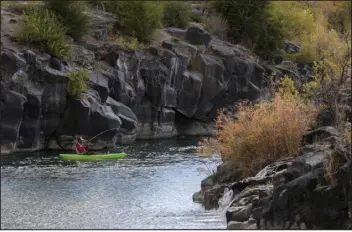  ?? JOAN ROARK — IDAHO POST-REGISTER ?? A man hooks a fish on the Snake River in Idaho Falls, Idaho, in 2020. Some top officials in the state are raising alarms over the Republican attorney general’s decision not to join a 24-state lawsuit against new waterway protection­s by the Biden administra­tion.