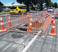  ?? PHOTO: DANIEL BIRCHFIELD ?? Fenced off . . . Motorists negotiate a fencedoff sinkhole in Reed St that opened up in late December. Work to fill and seal the area was scheduled to start yesterday.