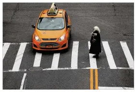  ?? SPENCER PLATT / GETTY IMAGES ?? A woman walks through a Manhattan intersecti­on Thursday in New York City. According to new figures released by the Governors Highway Safety Associatio­n, pedestrian deaths on American roads are climbing faster than motorist fatalities and reached nearly...