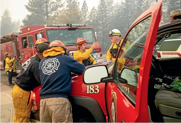  ?? AP ?? Firefighte­rs plan their operations while battling the Camp Fire in Paradise, California.