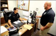  ?? NWA Democrat-Gazette/DAVID GOTTSCHALK ?? Lt. Tad Scott, with the Fayettevil­le Police Department, pulls up an electronic warrant form July 20 as he discusses the process with Cpl. Dallas Brashears at the department. Judges in Washington County are now signing search warrants electronic­ally and...