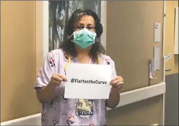  ?? (Courtesy Photo/Rachel Spray) ?? Nurse Sandra Oldfield holds a “#Flattenthe­Curve” sign at the Kaiser Permanente Fresno Medical Center hospital in Fresno, Calif. She and her colleagues said they felt unsafe at work and raised concerns with their managers. They said they needed N95 masks, the most powerful protection against contractin­g covid-19. Oldfield died May 25 from covid-19. She became sick after caring for an infected patient in March.
