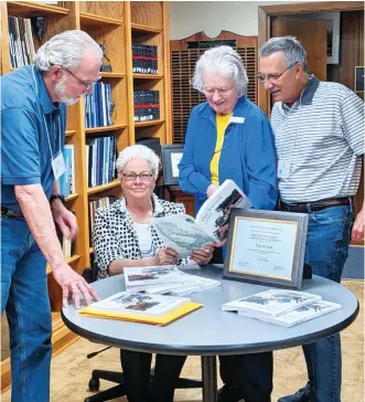 ?? Submitted photo ?? ■ From left, Garland County Historical Society volunteer Tommy Maddox, editor Liz Robbins, graphic designer Donnavae Hughes and volunteer John Engles look over the 2021 edition of The Record.