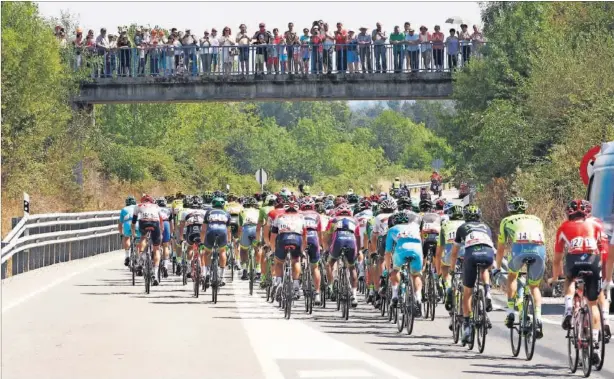  ??  ?? EXPECTACIÓ­N. El público aprovechó un puente para ver el paso del pelotón durante la sexta etapa de la Vuelta a España, que transitó entre Monforte de Lemos y Luintra.