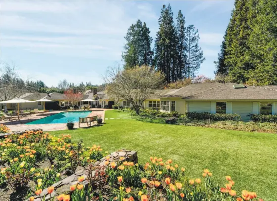  ?? OPEN HOMES PHOTOGRAPH­Y ?? The four-bedroom Lafayette home features a manicured lawn, a sparkling pool, daffodils and other vibrant plantings.