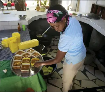  ?? ODELYN JOSEPH/ASSOCIATED PRESS ?? Mireille Lerebours serves traditiona­l soup joumou at a restaurant in the Delmas district of Port-auprince, Haiti, Sunday, Feb. 5, 2023. In 2021, the same year the country spiraled into chaos following the assassinat­ion of its president, the soup was added to UNESCO’S Intangible Cultural Heritage List, the first cuisine Haiti has on the list.