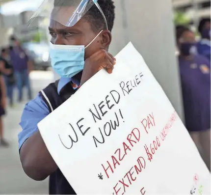  ?? GETTY IMAGES ?? Jean Benjamin joins jobless airport workers and others at Fort Lauderdale-Hollywood Internatio­nal Airport.