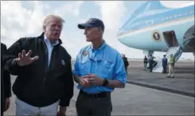  ?? AP PHOTO/ EVAN VUCCI ?? Gov. Rick Scott, R-Fla., right, looks on as President Donald Trump talks with reporters after arriving at Eglin Air Force Base to visit areas affected by Hurricane Michael on Monday in Eglin Air Force Base, Fla.