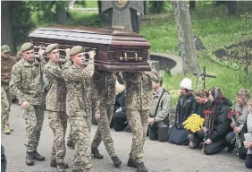  ?? CHRISTOPHE­R FURLONG GETTY IMAGES ?? Mourners attend the funeral of Denys Antipov, a soldier and popular economics lecturer at the Kyiv School of Economics, on Wednesday in Kyiv, Ukraine.