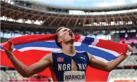  ?? Photograph: Patrick Smith/Getty Images ?? Karsten Warholm celebrates after winning the 400m hurdles. The Norwegian set a world record time despite not wearing super spikes.