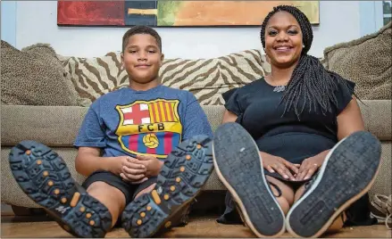  ?? STEVE SCHAEFER PHOTOS / SPECIAL TO THE AJC ?? Nicki and her 10-year-old son, Nolan, try on her father’s shoes, ranging from wingtip Oxfords to casual boat shoes.