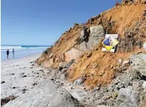  ??  ?? A sign warns beachgoers to avoid a section of coastal bluff that collapsed Sunday in Del Mar.