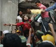  ?? KEVIN FRAYER/THE ASSOCIATED PRESS FILE PHOTO ?? A woman is lifted out of the rubble at the collapsed Rana Plaza garment factory building, near Dhaka, Bangladesh.