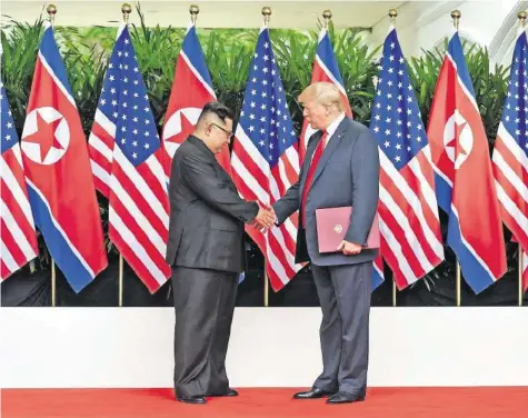  ?? AFP ?? Historisch­es Treffen in Singapur: Kim Jong-un und Donald Trump geben sich die Hand.