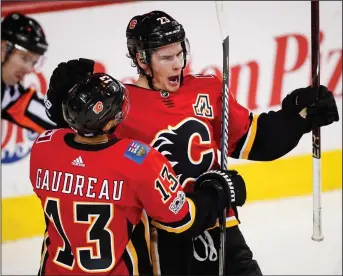  ?? CP PHOTO JEFF MCINTOSH ?? Calgary Flames' Sean Monahan, right, celebrates his goal with teammate Johnny Gaudreau during third period NHL hockey action against the Pittsburgh Penguins in Calgary.