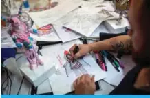  ??  ?? Leandro Vieira, 34, artistic director of the Mangueira samba school, draws a costume inside their barrack at Cidade do Samba (City of Samba), where costumes and floats for Rio’s Carnival are made, in Rio de Janeiro.