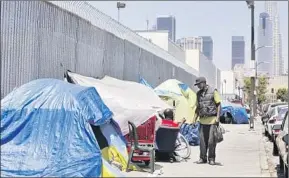  ?? Genaro Molina Los Angeles Times ?? TWO MEN talk on skid row in 2016. The homeless crisis could be to L.A., the 2028 Summer Olympics host, what the Fukushima controvers­y is to the 2020 Tokyo Games.