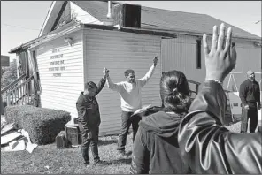  ?? AP/St. Louis Post-Dispatch/J.B. FORBES ?? Pastor David Triggs and his wife, Charronda, hold an outdoor service after a fire earlier this month at New Life Missionary Baptist Church in St. Louis.