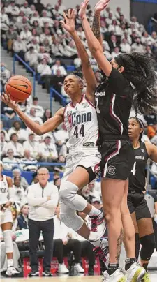  ?? Tyler Sizemore/Hearst Connecticu­t Media ?? UConn guard Aubrey Griffin, left, makes a layup over South Carolina forward Kamilla Cardoso on Sunday.