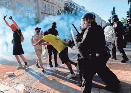  ?? ROBERTO SCHMIDT/AFP VIA GETTY IMAGES ?? U.S. Park Police advance on peaceful protesters Monday as President Trump addressed the nation from the White House. Shortly after, he walked through the cleared scene to St. John’s Episcopal Church.