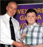  ??  ?? Patrick O’Hara accepts Shannon Buckley’s award from Chief Superinten­dent John Roche.