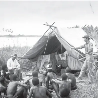  ??  ?? Snapshots of the past ... masked dancers at Tovei village in Gulf Province (opposite page); Frank Hurley and Allan McCulloch on the Aramia River in Western Province (left).