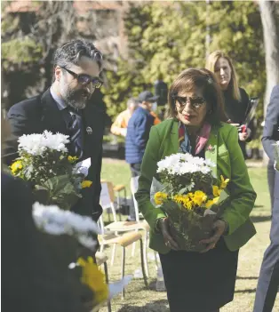  ?? IAN KUCERAK ?? Lt. Gov. Salma Lakhani and Dr. Hamed Esmaeilion, spokesman for the Associatio­n of Families of Flight PS752, carry flowers during the unveiling of a U of A memorial site honouring local victims of the disaster.