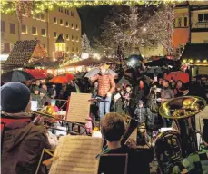  ?? FOTOS: SIEGFRIED HEISS ?? Das Jugendblas­orchester der Musikschul­e Ravensburg hat den Christkind­lesmarkt festlich eröffnet. So wie viele Besucher ließ sich auch Familie Ludolph aus Ravensburg (rechts) die Eröffnung nicht entgehen – obwohl es ein wenig regnete.