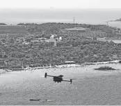 ?? THANASSIS STAVRAKIS/AP ?? A long-range drone equipped with thermal imaging cameras and a sophistica­ted early warning system patrols over Kavouri beach and nearby woodlands Aug. 17 in southern Athens, Greece.