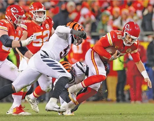  ?? KEVIN C. COX/GETTY IMAGES ?? Chiefs quarterbac­k Patrick Mahomes scrambles away from two Bengals defenders during the fourth quarter Sunday.