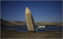  ?? JOHN LOCHER — THE ASSOCIATED PRESS, FILE ?? A formerly sunken boat sits upright into the air with its stern stuck in the mud along the shoreline of Lake Mead in June 2022 at the Lake Mead National Recreation Area near Boulder City, Nev. In November 1922, seven land-owning White men brokered a deal to allocate water from the Colorado River, which winds through the West and ends in Mexico.