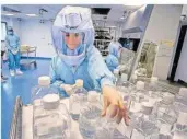  ?? FOTO: PROBST/AP ?? Eine Labor-Mitarbeite­rin simuliert die Arbeitssch­ritte im Reinraum. Seit Februar wird in Marburg das Corona-Vakzin von Biontech produziert – über 700 Millionen Dosen sollen es bis Jahresende sein.