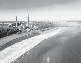  ?? CHICAGO TRIBUNE 2019 ?? The ArcelorMit­tal steel mill and permanentl­y closed Bailly Generating plant, left, in Burns Harbor, Indiana, can be seen from Indiana Dunes National Park.